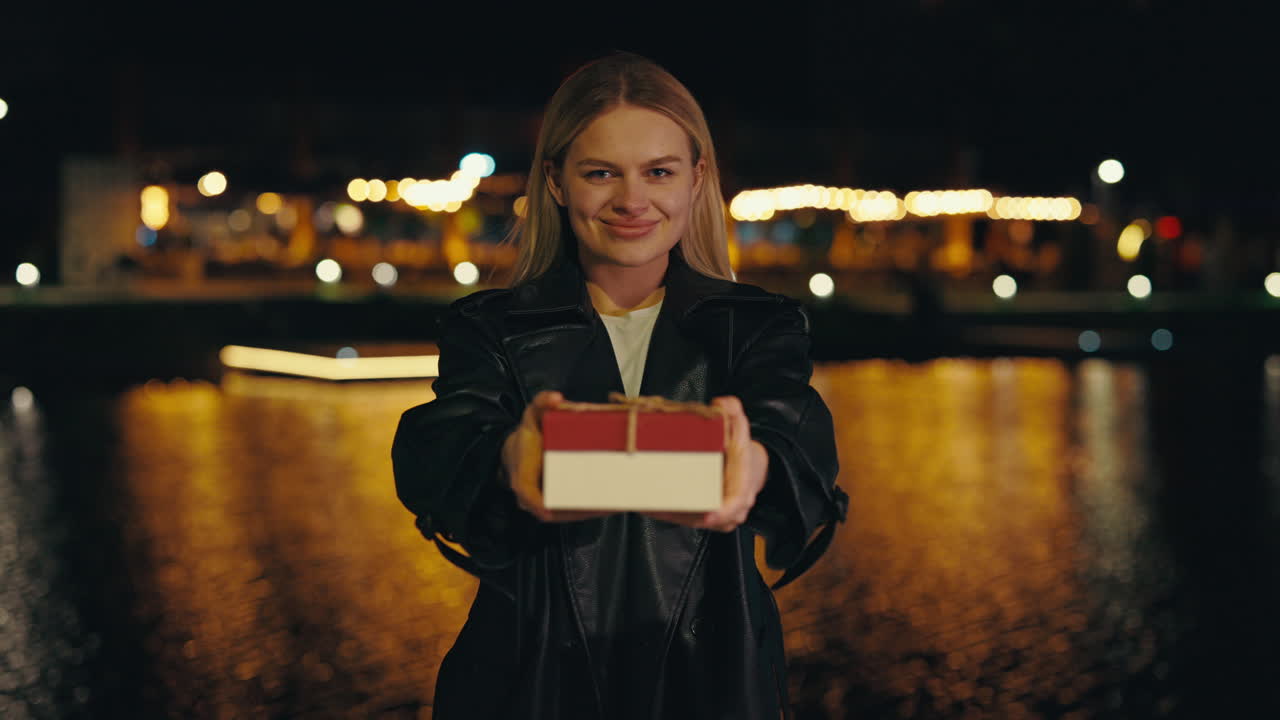 A woman holding a gift at night