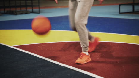 primer plano de una jugadora de baloncesto que rebota la pelota en la cancha al aire libre por la noche 1