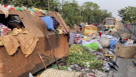 road sideway covered in piles of garbage in dhaka city, handheld view