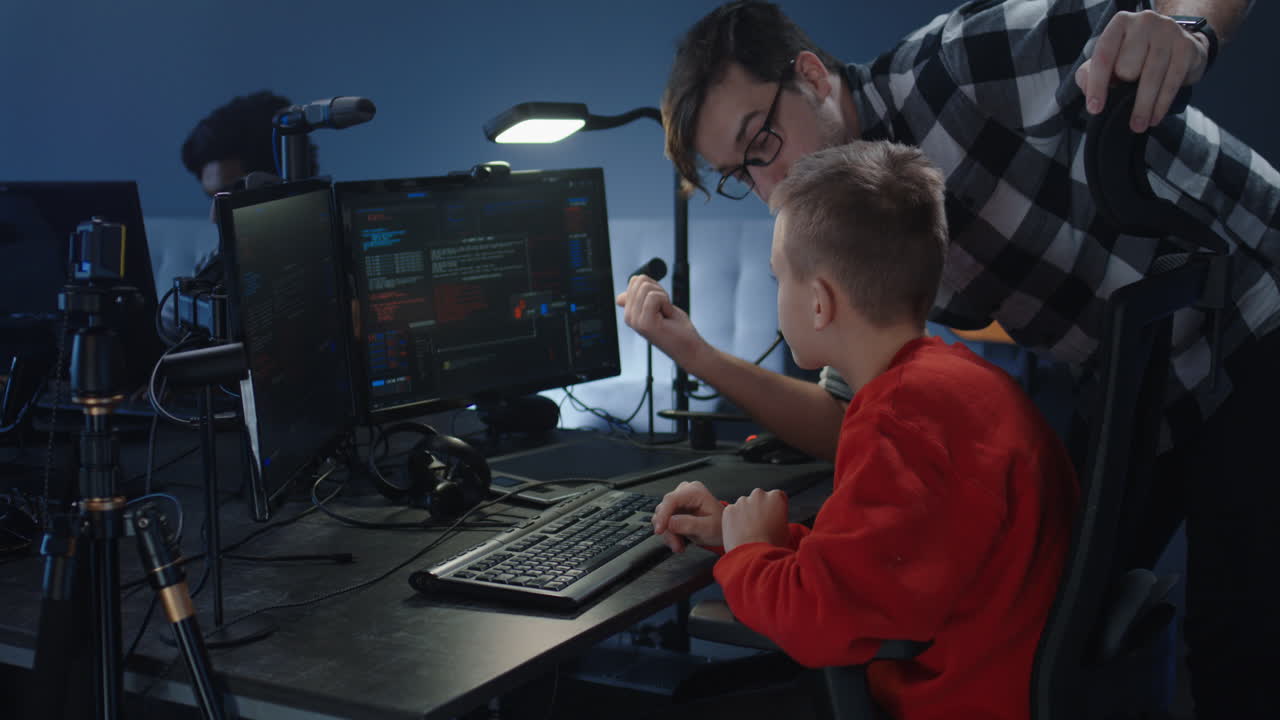 Boy learning coding from a teacher