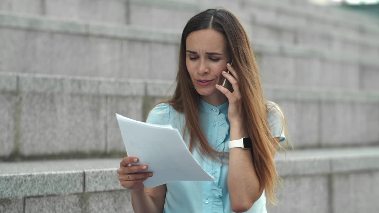 mujer de negocios hablando en el teléfono inteligente en la calle. ejecutivo mirando documentos