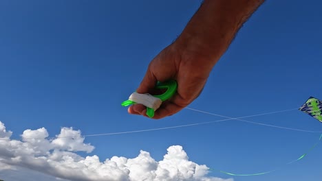 incredible point of view of adult hands flying green kite by holding green string reels