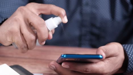 person sanitizing a smartphone