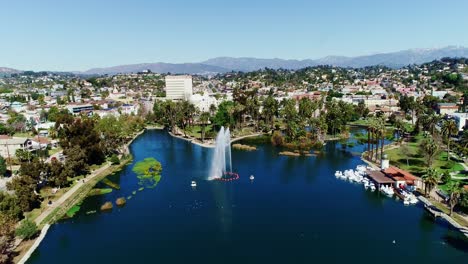 beautiful drone shot of echo park lake, surrounded by greenery and mountains