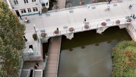 pedestrians crossing famous hoogbrug, mechelen oldest stone bridge, belgium - aerial