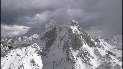 snowy mountain range under stormy sky