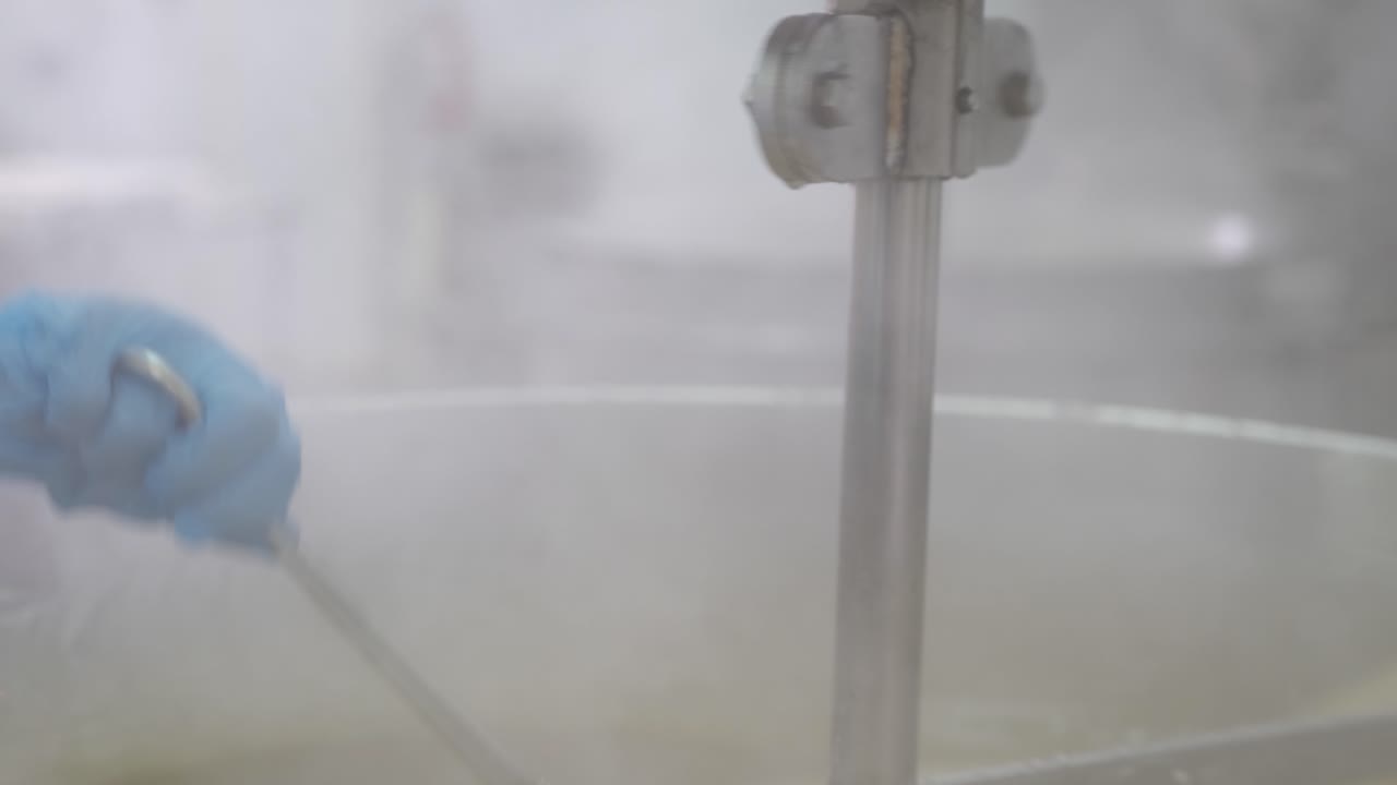 primer plano de sumergir una espátula en una tina de delicias turcas en la fábrica para verificar la consistencia y ver si el lote está listo