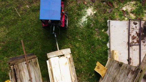 Top-down-view-of-tractor-with-trailer-loaded-with-planks-driving-out-of-sawmill