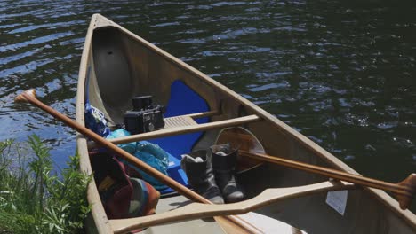 una canoa se sienta tranquilamente en la orilla de un río