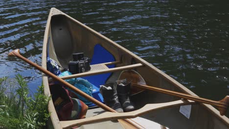 a canoe sits calmly on a river shore