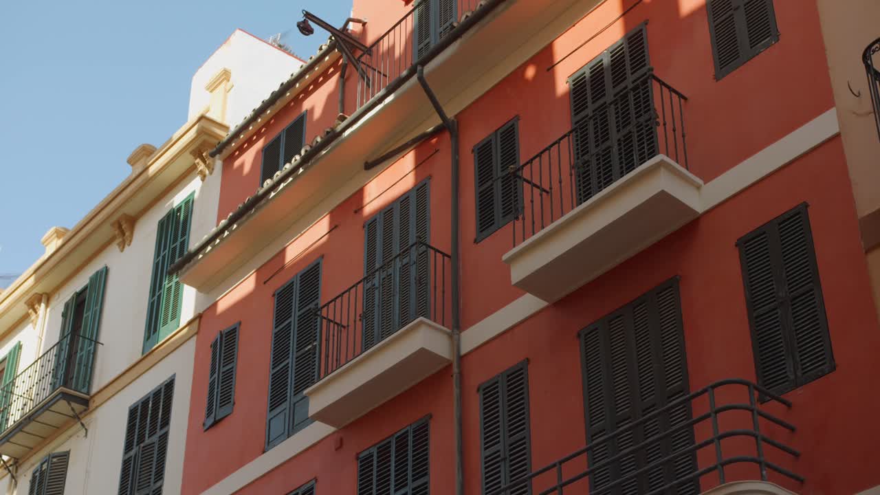 Capturing of spainsh architecture colorful buildings with small balconies and windows in Palma de Majorca, Spain. 4k.