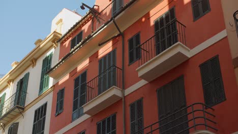 capturing of spainsh architecture colorful buildings with small balconies and windows in palma de majorca, spain. 4k.