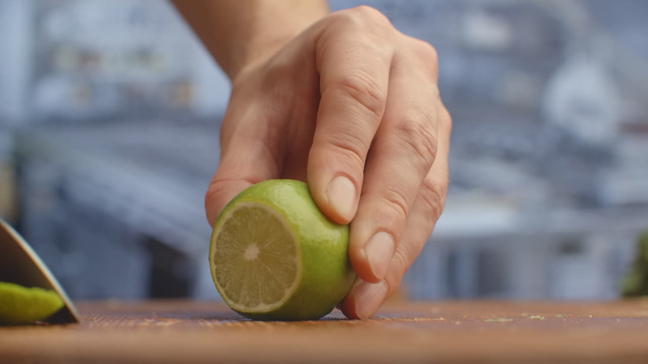 Cut with a knife on a wooden board closeup green lime in the kitchen. shred