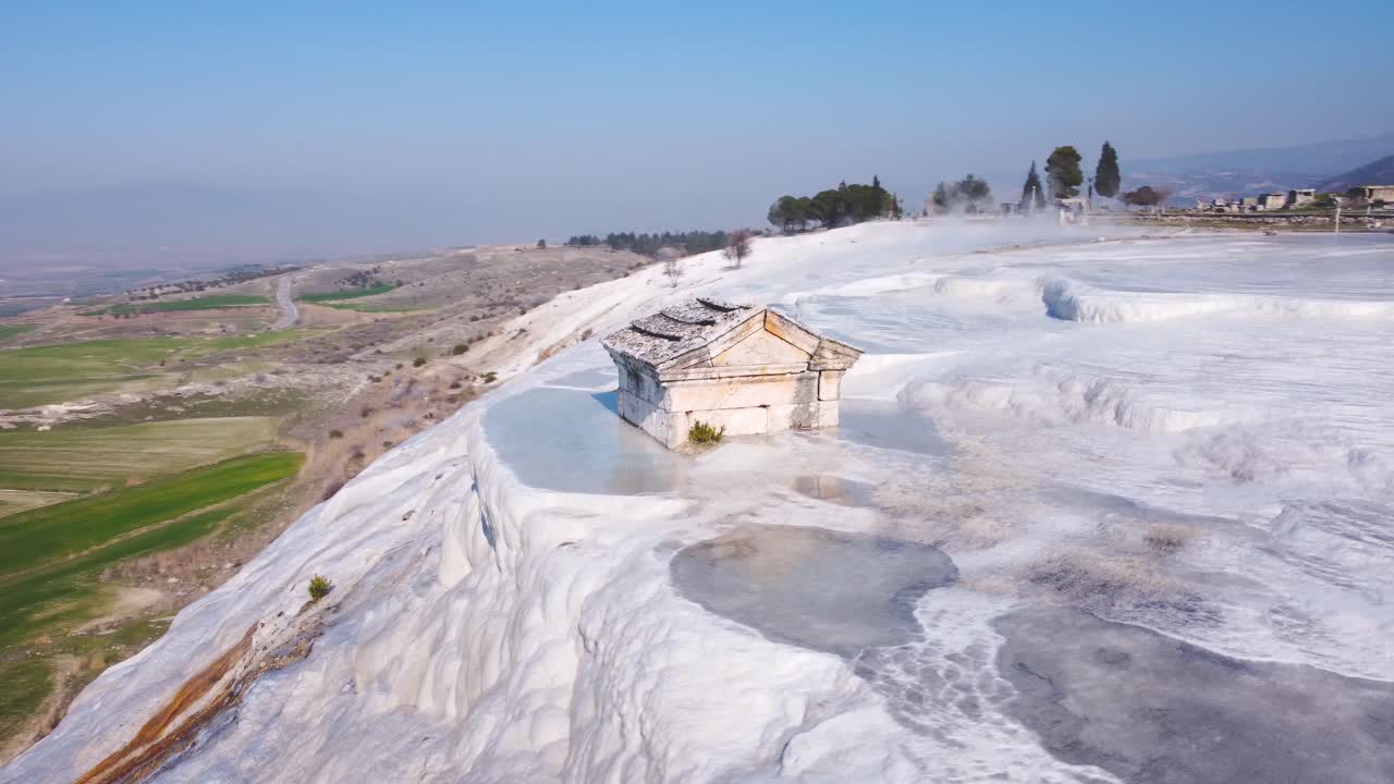 Pamukkale, Turkey , natural hot springs and thermal baths, ancient stone grave tomb on travertine limestone mineral deposit formations