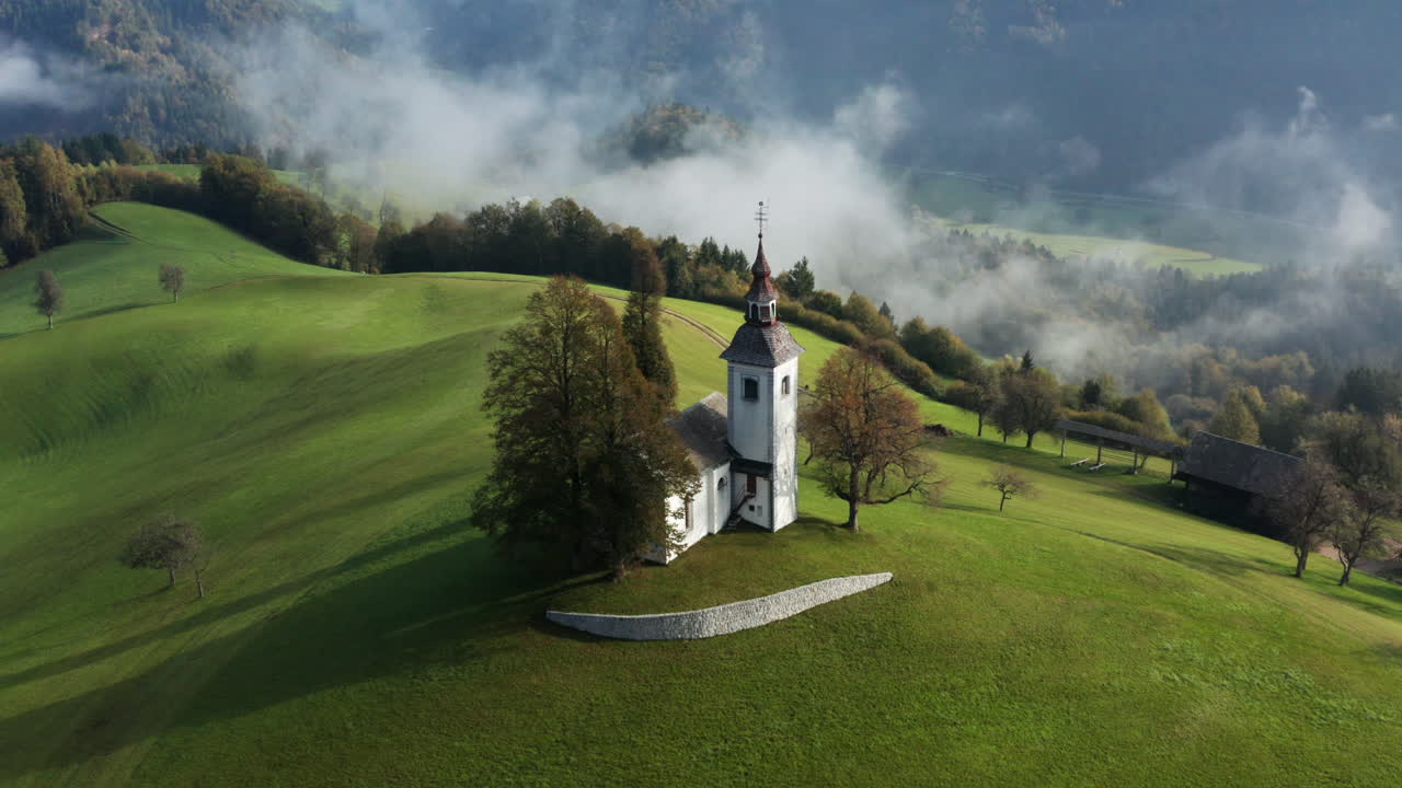 St. Thomas Church Nestled In The Hills Near The Town Of Skofja Loka In Slovenia - Drone Shot