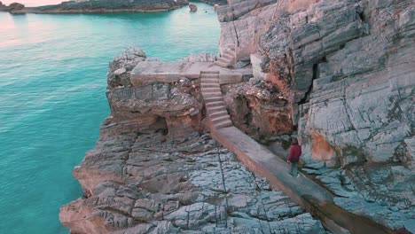 aerial forward drone shot showing a woman walking on a path