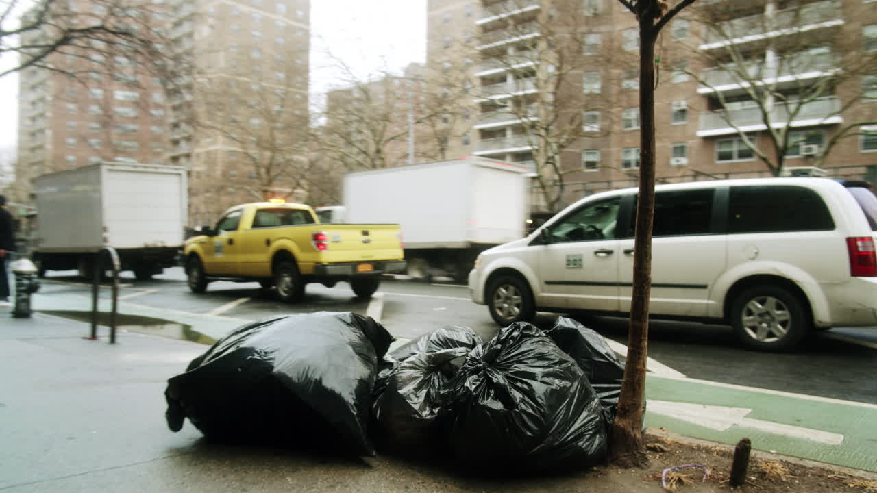 Street scene with garbage bags and passing van