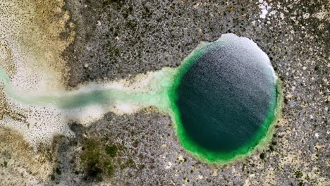 bahamas aerial view: blue hole and channel, top-down rising perspective