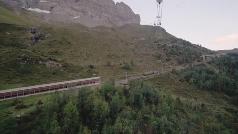 shot from inside a mountain cableway looking out over a moving mountain train in switzerland in 4k