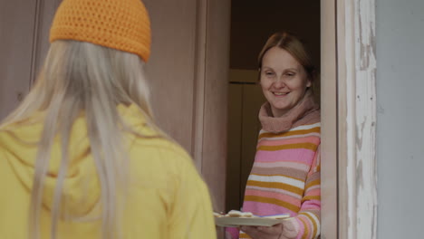 the child comes to get candy at the door of the house. woman opens the door and gives a treat