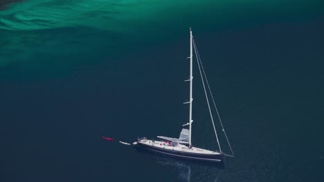 sailboat without sails floating in the calm blue sea in norway