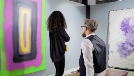 art lovers viewing abstract paintings in a gallery