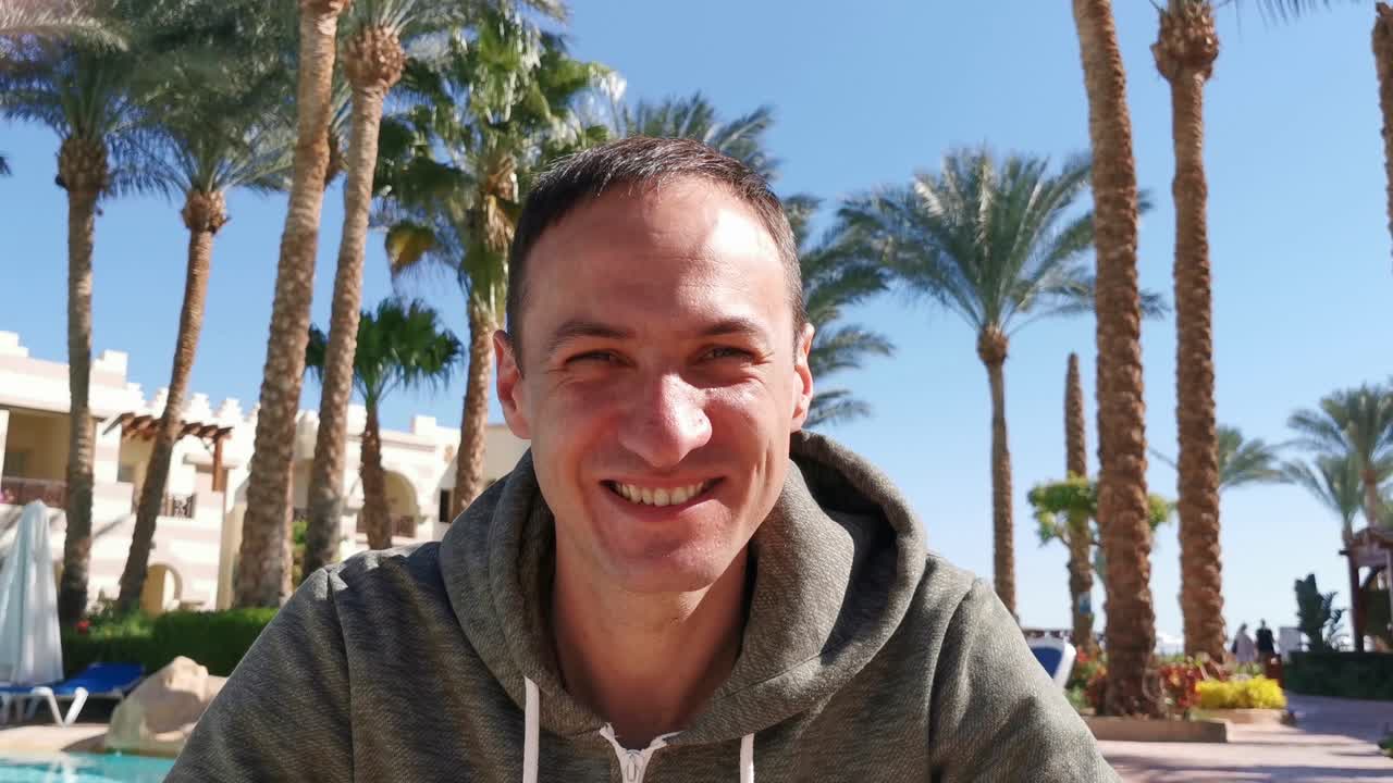 hombre con un disparo en la cabeza video chat cerca de las palmeras