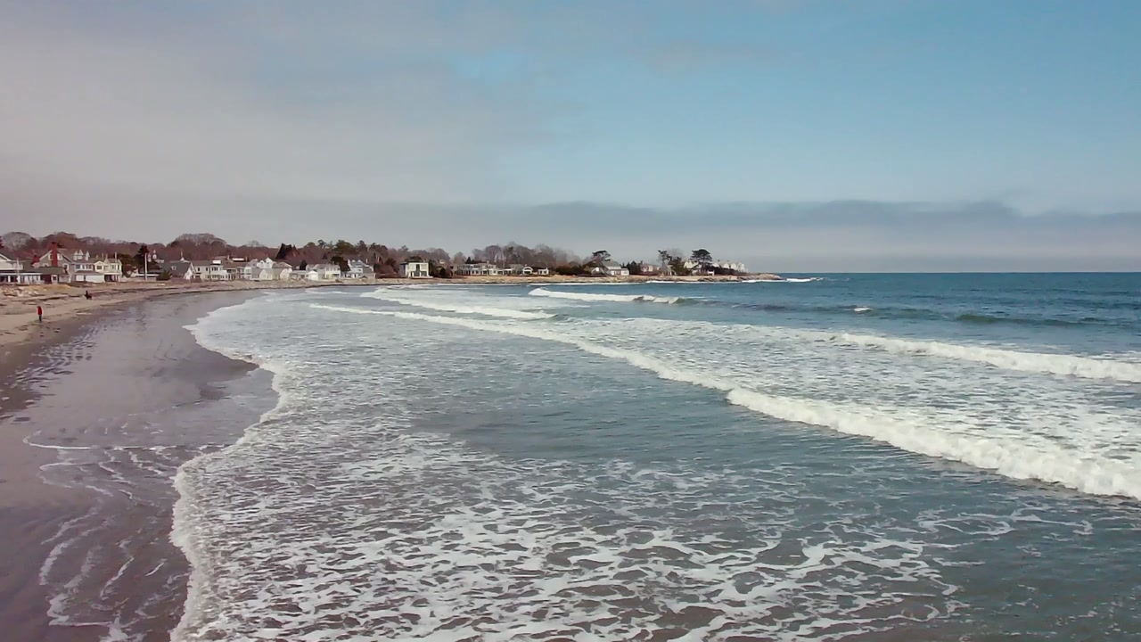 Sandbanks Beach with gentle waves along sandy shoreline and houses lining coast showing calm seaside landscape and residential coastal environment