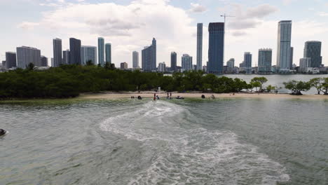 Aerial-view-following-water-jets-arriving-at-the-Pace-Picnic-Island,-in-sunny-Miami