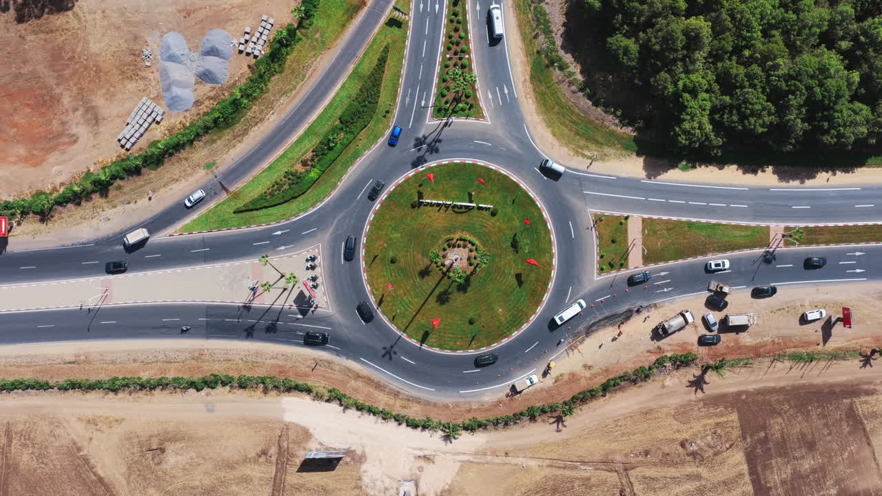 Straight-down drone view of a landscaped roundabout near Casablanca, with surrounding traffic, greenery, and construction areas visible