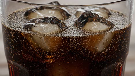 a close-up perspective of refreshing carbonated beverage with ice cubes and bubbles in a glass, perfect for quenching thirst on a hot day