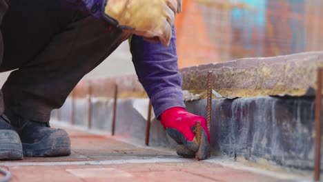 Close-up-shot-of-builder-working-on-construction-site-hammering-nail-into-floor