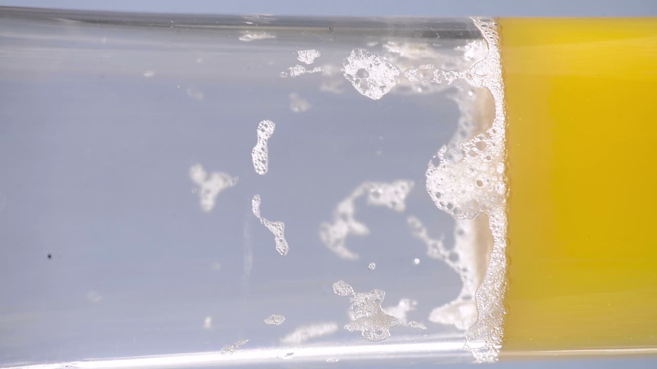 Cloudy hazy pilsner ale beer being poured on a glass
