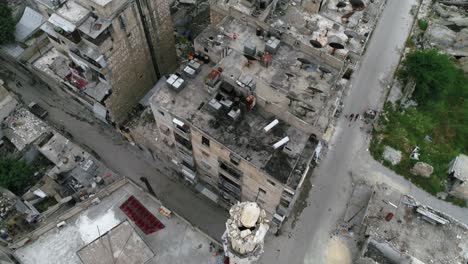 drone view above rooftops of buildings in aleppo. we can see birds and people on the rooftop in the destroyed city of syria 4k