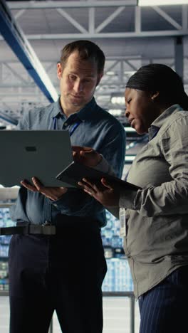 vertical video team of data center programmers monitoring deep learning processes with laptop
