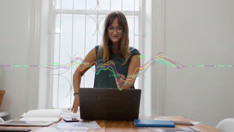 animación de gráficos multicolores sobre una mujer caucásica pensativa mirando la pantalla de una computadora portátil