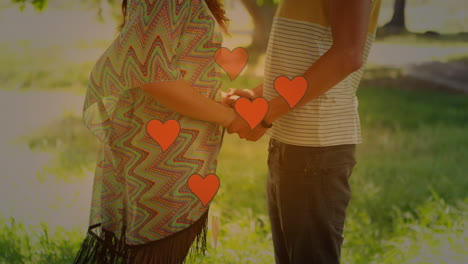 animation of heart icons over caucasian couple holding hands