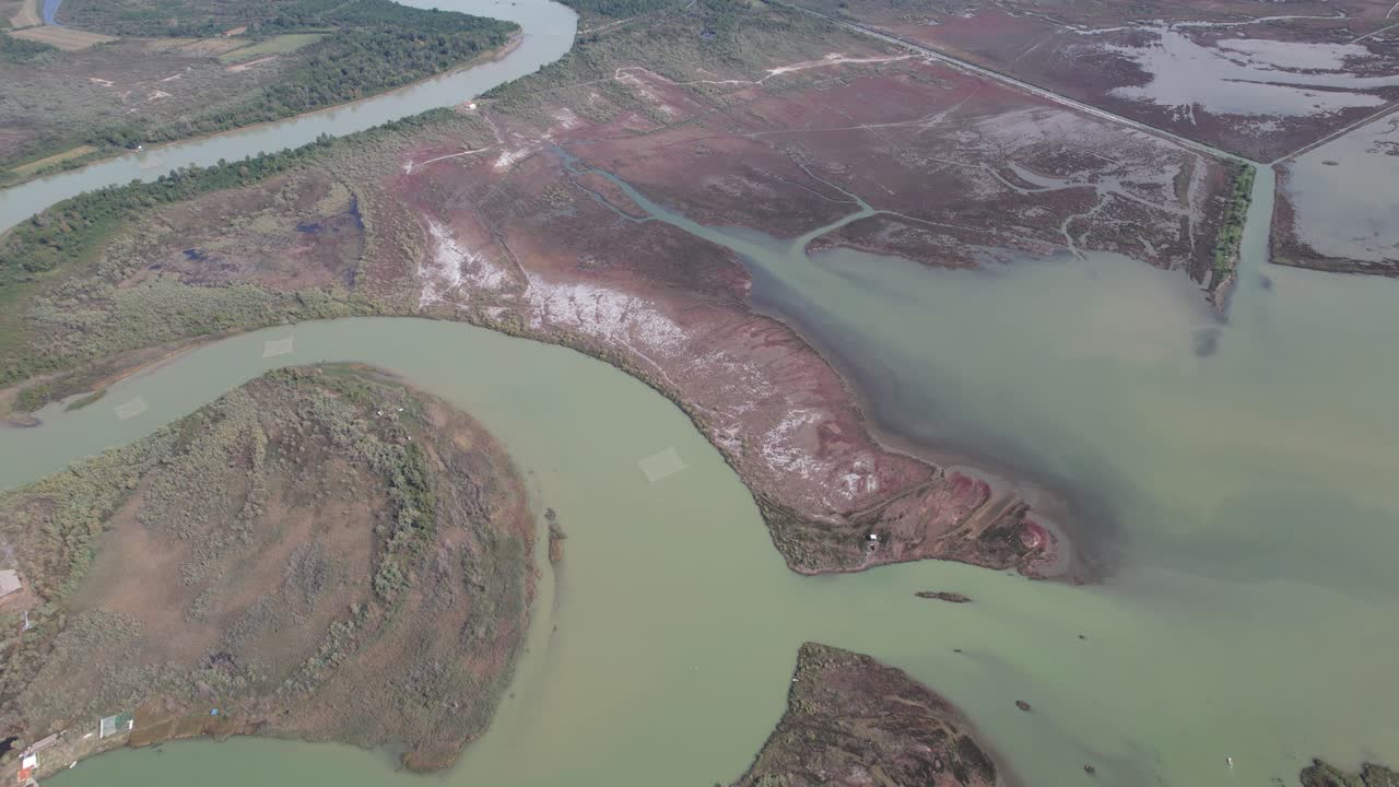 el río serpentea a través de la laguna trayendo el agua turbia, se desborda y se extiende, inundando las tierras en albania