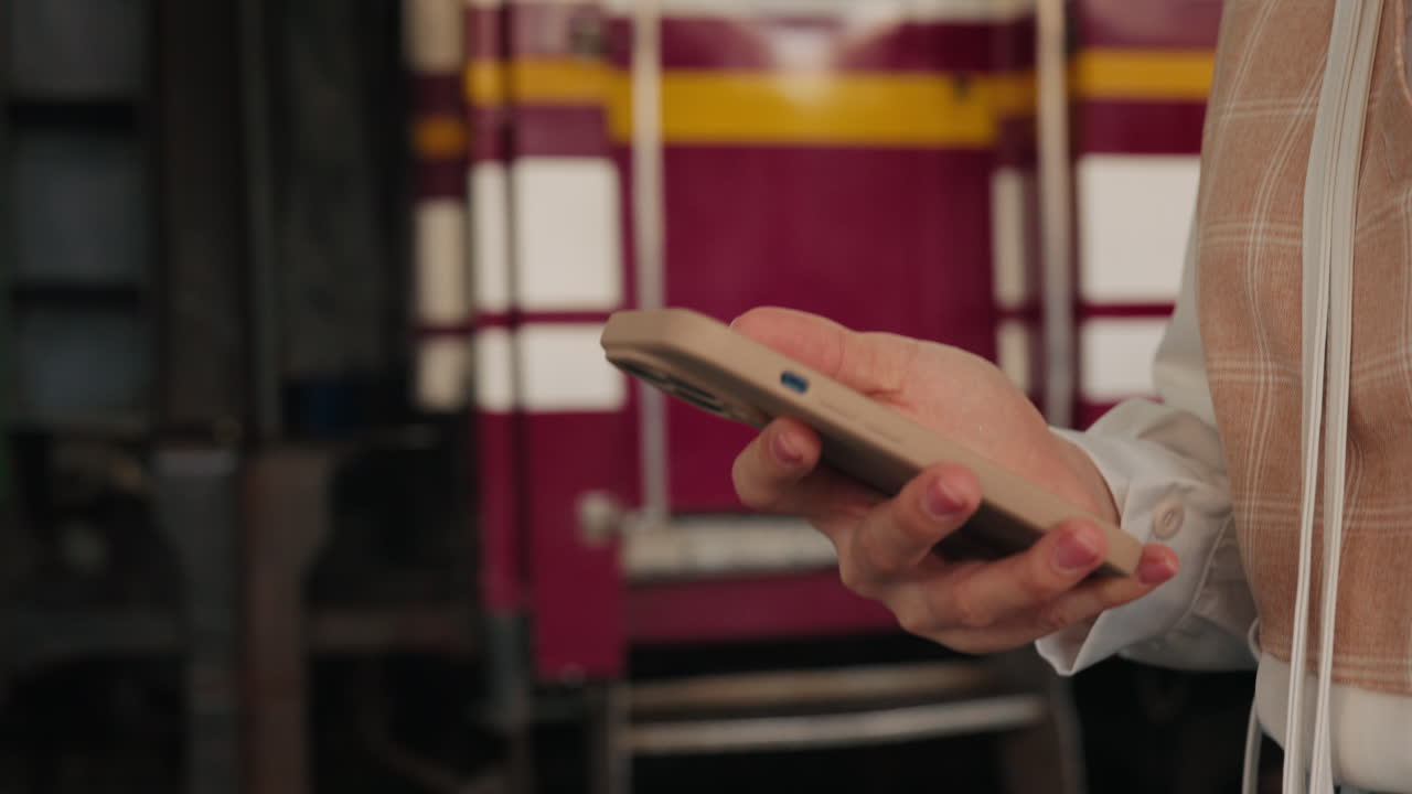 mujer usando el teléfono en una estación de tren