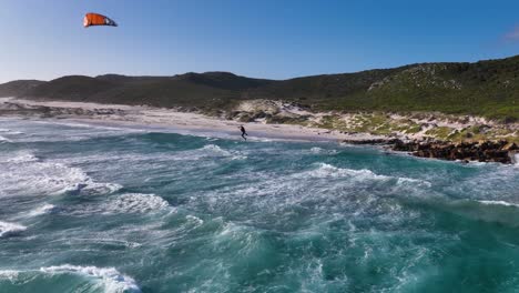 Extreme-kitesurfing-on-powerful-waves-in-Cape-of-Good-Hope,-aerial-orbit-view