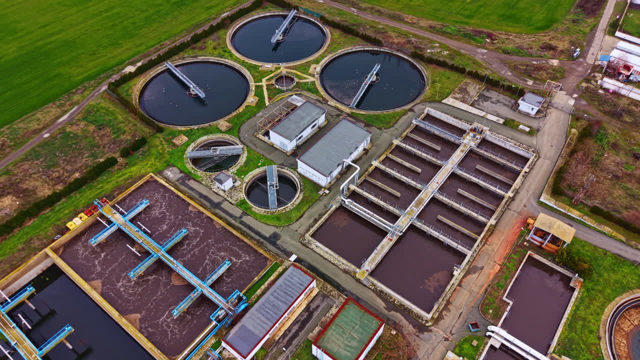 Water treatment facility operates in open land with several tanks and processing units for wastewater management and purification