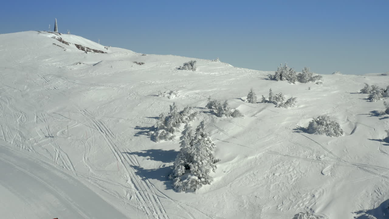 Snowcats grooming a ski slope on a sunny winter mountain