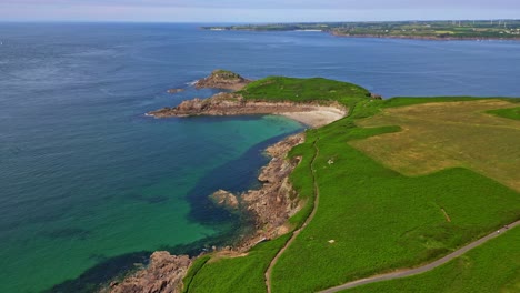 presqu'île de kermorvan in brittany, rugged coastline, green fields, sandy cove, turquoise waters of atlantic, france. aerial drone panoramic view