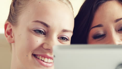 dos mujeres jóvenes usando una tableta con pantalla táctil ipad