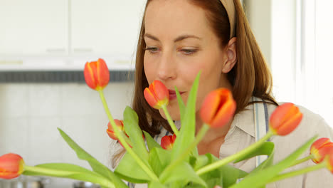 pretty woman arranging a vase of orange tulips