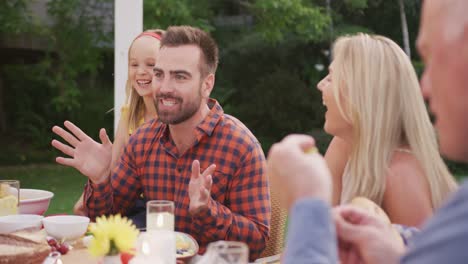 Three-generation-family-enjoying-lunch-outdoors