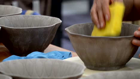 traditional pottery making, close up of potter's hands shaping a bowl on the spinning by clay