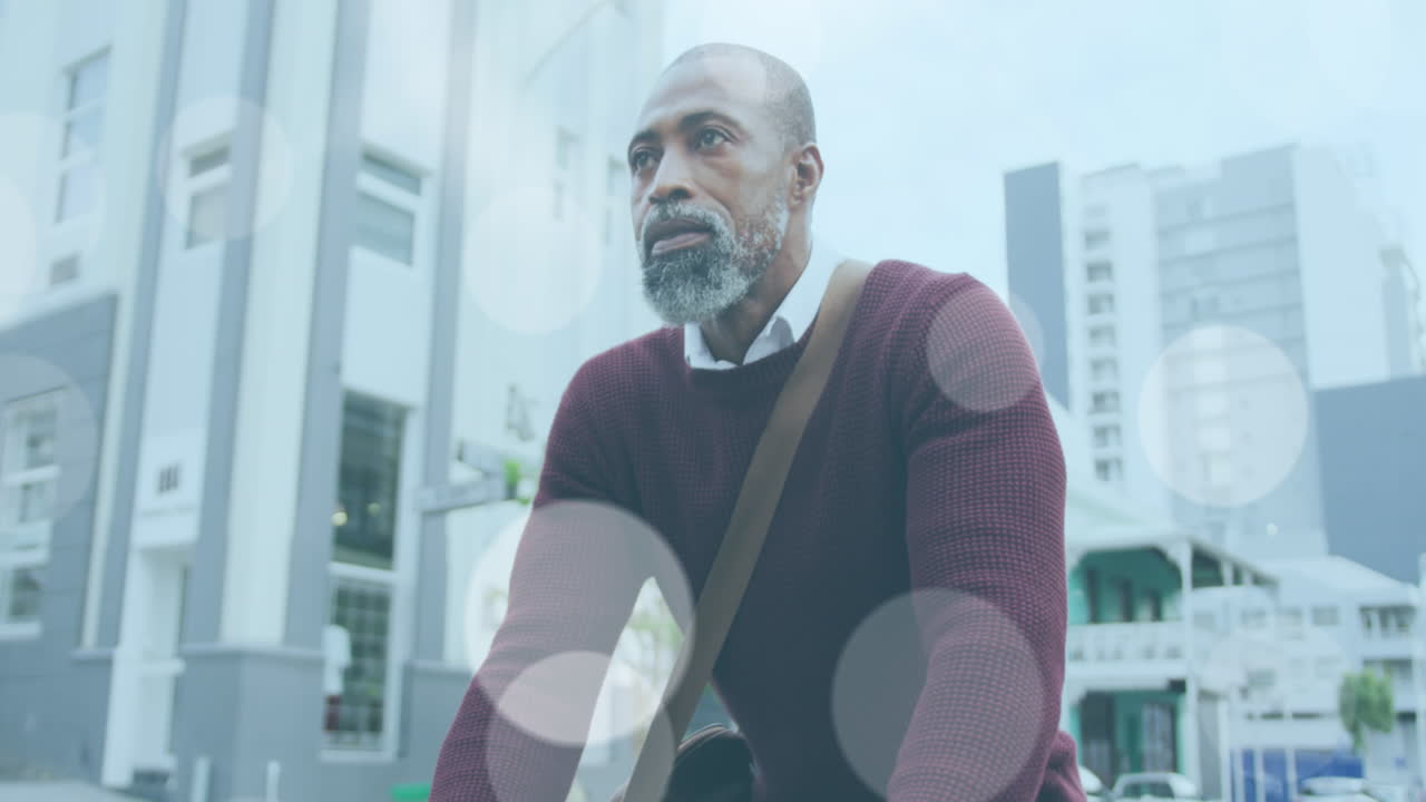 Animation of light spots over african american man cycling