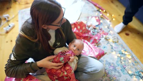 mother and baby unwrapping christmas presents