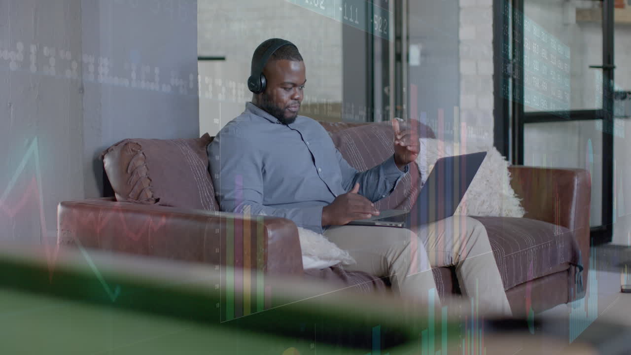 Graphs processing data over african american casual businessman having laptop video call